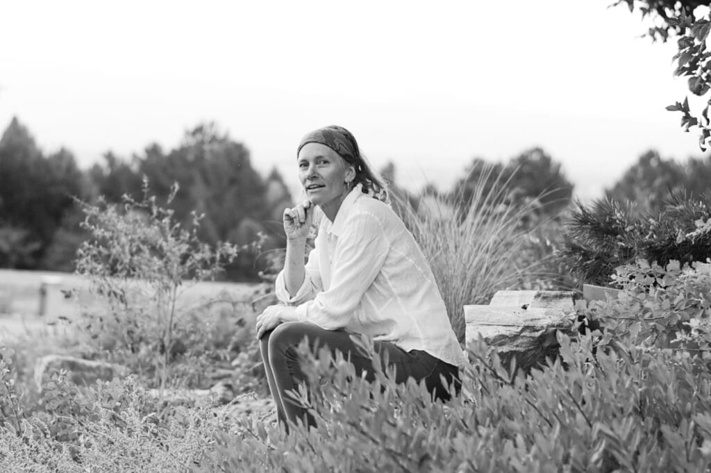 Lady sitting on rock outside with chin on hand